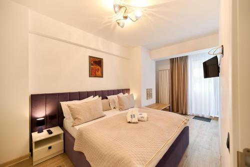 a bedroom with a bed with two candles on it at Nikola Apartment Infinity Resort in Mamaia