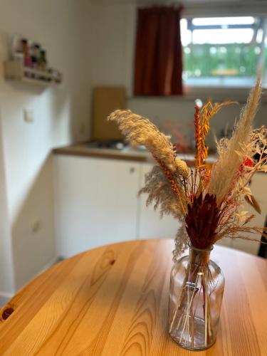 a glass vase with dry grass in it on a table at Perfect getaway in Bruges! in Bruges