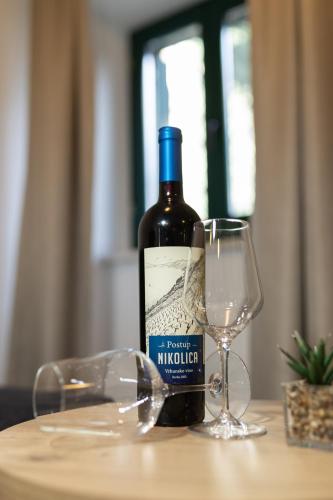 a bottle of wine sitting next to a wine glass at Apartments Korta in Split