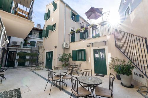 a patio with tables and chairs in front of a building at Apartments Korta in Split