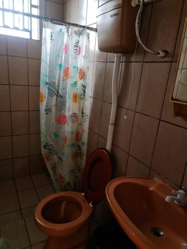 a bathroom with a toilet and a shower curtain at Retiro The Chosen in Mosqueiro