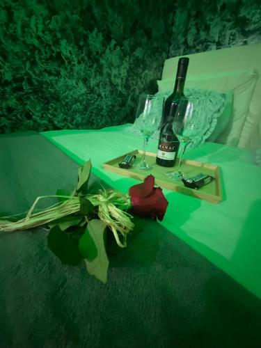 a bottle of wine and glasses on a table at Love spa apartman in Banja Koviljača