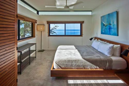 a bedroom with a bed and a desk and a window at Casa Colibri - Stunning ocean view in Santa Teresa Beach