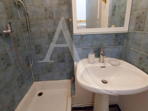 une salle de bain avec un lavabo et un miroir dans l'établissement LES GRANGETTES, 4 pers, terrasse et parking, à Sète
