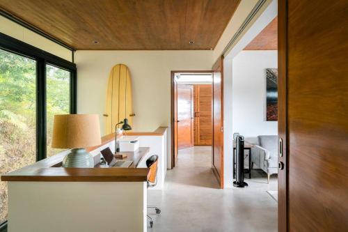 a home office with a desk and a surfboard at Casa Colibri - Stunning ocean view in Santa Teresa Beach
