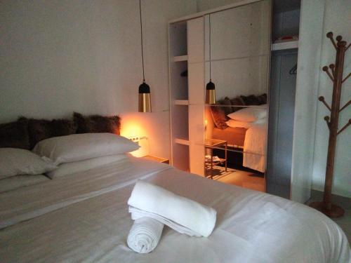 un letto bianco con un rotolo di asciugamani sopra di Homestay Omah a Tabanan