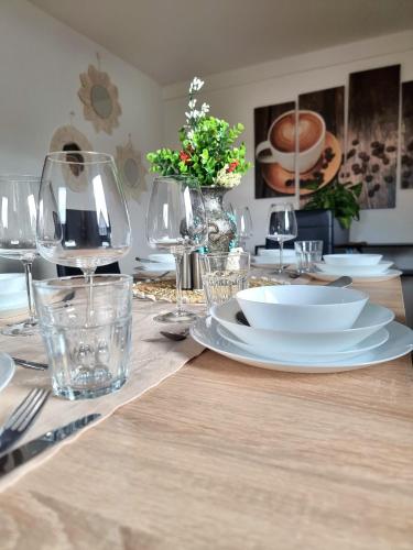 a dining table with white plates and wine glasses at FeWo Lichtblick in Mengen