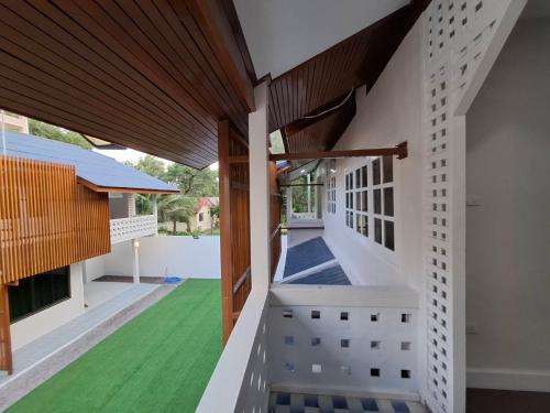 an external view of a house with a green lawn at Brown House Cha am in Cha Am