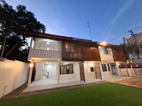 a house with a balcony on top of it at Brown House Cha am in Cha Am