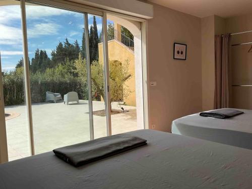 une chambre avec un lit et une grande fenêtre en verre dans l'établissement Villa 5 étoiles avec Magnifique Vue au Domaine des Cigales, à Aubignan