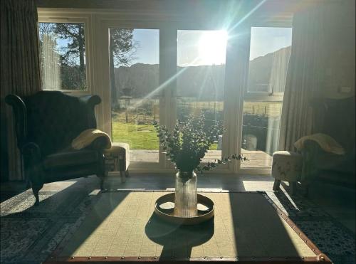 a living room with a vase with flowers in it at Bridge House Hotel & Silver Howe View Cottage in Grasmere