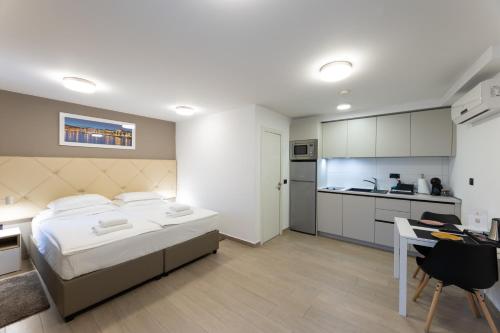 a bedroom with a bed and a desk and a kitchen at Apartments Korta in Split