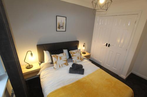 a bedroom with a large bed with two lamps at 4 Bedroom House Near Manchester Airport, Wythenshawe Hospital and Trafford Centre in Wythenshawe