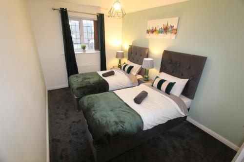 a bedroom with two beds and a window at 4 Bedroom House Near Manchester Airport, Wythenshawe Hospital and Trafford Centre in Wythenshawe