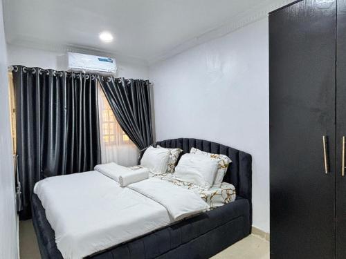 a black bed in a room with a window at Cozy Twin 5 in Lekki