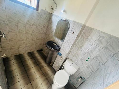 a bathroom with a toilet and a mirror at Weligama Resort in Badulla