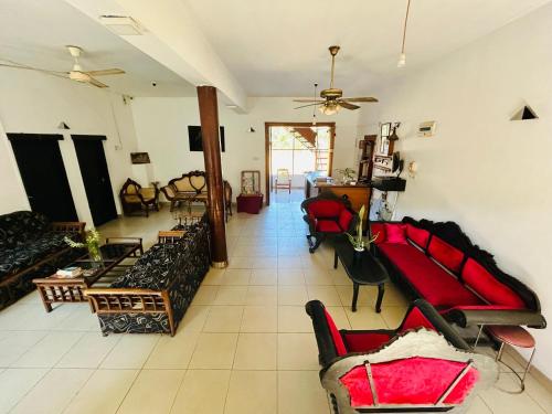 a large living room with couches and chairs in it at Weligama Resort in Badulla