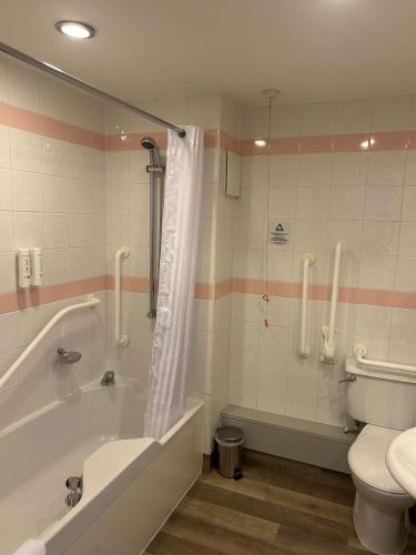 a bathroom with a tub and a toilet at Best Western Appleby Park Hotel in Tamworth