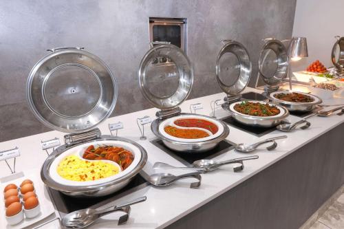 a buffet with many bowls of food on a counter at Garden Court Mthatha in Mthatha