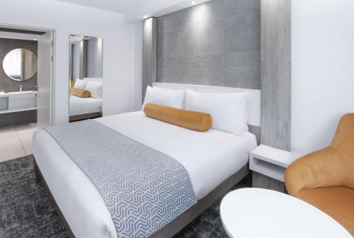 a bedroom with a large white bed and a chair at Garden Court Mthatha in Mthatha