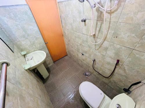a bathroom with a shower and a toilet and a sink at Weligama Resort in Badulla