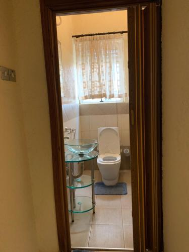 a bathroom with a toilet and a glass table at Furnished apartment Munyonyo-Kampala in Kampala