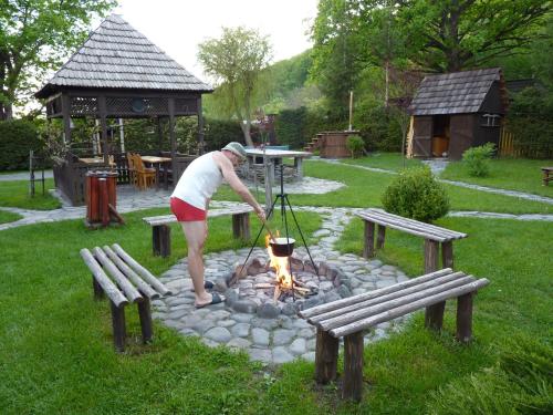 a woman standing over a fire in a fire pit at Nagy Lak I. in Sub Cetate