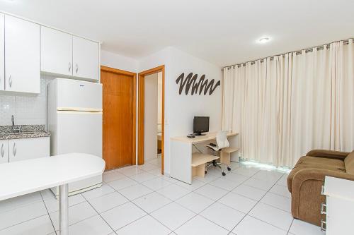 a room with a kitchen and a desk with a computer at Premier Hotel de Brasília 67961 in Brasilia