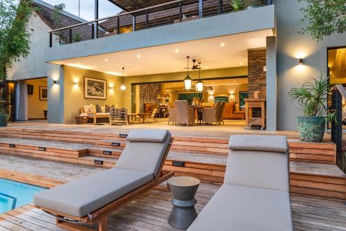 an outdoor deck with chairs and a pool at Elephant Point in Skukuza