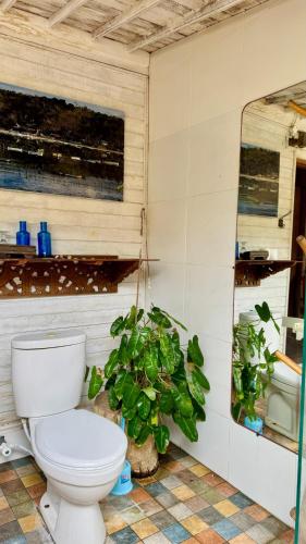 a bathroom with a toilet and a potted plant at Fisherman Shack in Nusa Lembongan