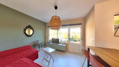 a living room with a red couch and a table at Residencial Las Dunas, Best Holiday Home Resort On The Island- VV in Corralejo