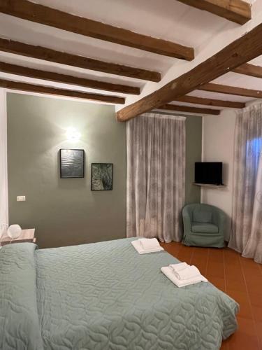 a bedroom with a green bed and a chair at Villaggio Della Salute Più in Monterenzio