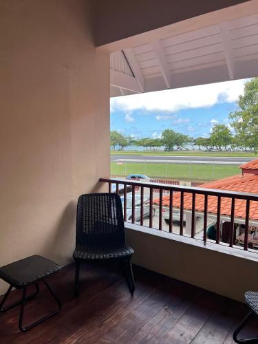 a balcony with a chair and a view of a field at Seaview Apartel in Castries