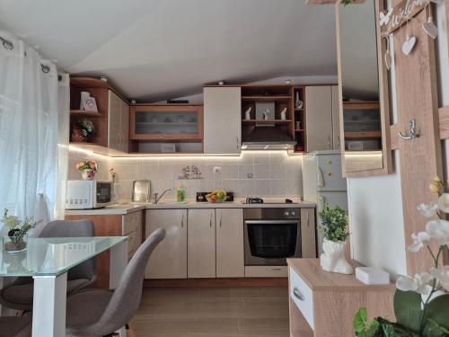 a kitchen with white cabinets and a glass table at Apartments Duje in Split