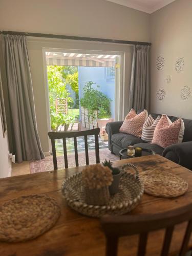 a living room with a table and a couch at Bloom and Berry Cottage in Hallack Rock