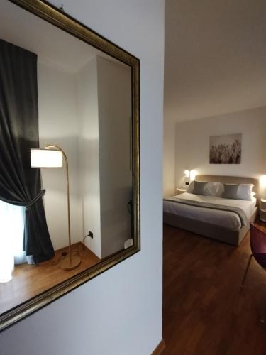 a bedroom with a large mirror and a bed at Palazzo Cusani Charming Rooms in Vercelli
