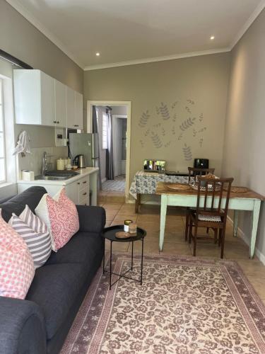 a living room with a couch and a table and a kitchen at Bloom and Berry Cottage in Hallack Rock