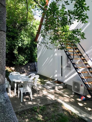 a small white house with a table and chairs at Quiet, green, relaxing place - 2 bedroom apartment in Balatonfüred