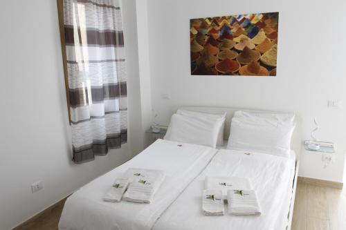 a bedroom with a white bed with towels on it at Tre Raggi Apartment in Venice