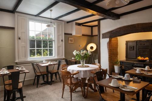 a dining room with tables and chairs and a window at Springfield House - Birmingham Airport & NEC in Coleshill