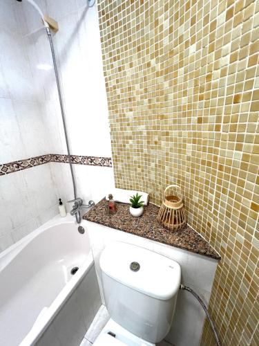 a bathroom with a toilet and a tub and a sink at Apartamento Forcat 25 in Cala en Forcat