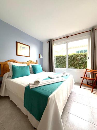 a bedroom with a large bed and a large window at Apartamento Forcat 25 in Cala en Forcat