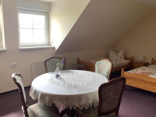 a room with a table and chairs and a bed at Pension Scherzer in Ohorn