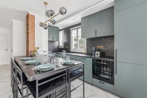 une cuisine avec des placards bleus et une table avec des assiettes. dans l'établissement Appartement Moderne à Cannes, à Cannes