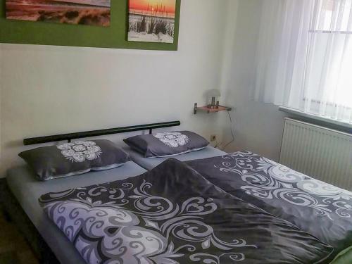 Una cama con dos almohadas encima en un dormitorio. en Ferienbungalow Kahmann, en Ribnitz-Damgarten
