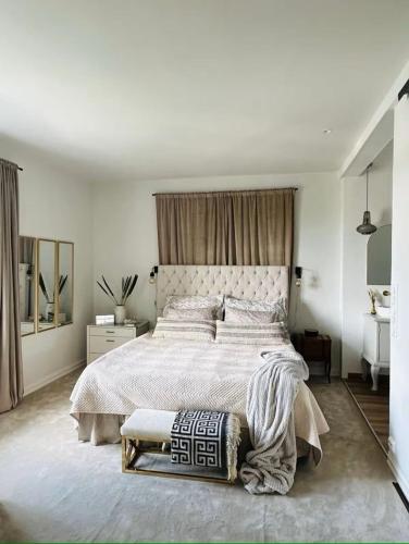 a white bedroom with a large bed and a mirror at Extravagant villa central & by the sea in Oslo
