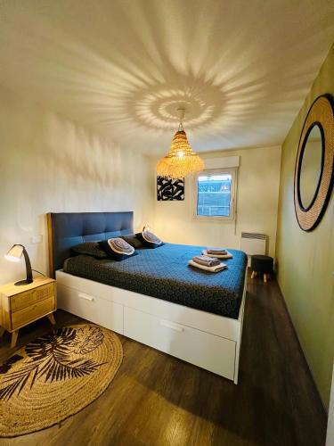 une chambre avec un grand lit avec une couette bleue dans l'établissement T2 Beaux Arts parking privé gratuit, à Montpellier