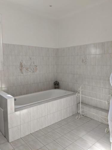 La salle de bains blanche est pourvue d'une baignoire et de carrelage. dans l'établissement Mas dans les lavandes, à Ménerbes
