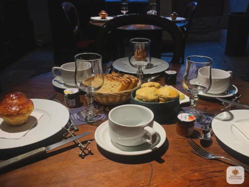 una mesa con platos, tazas y pasteles. en Algranate - Maison du Tisserand, en Flavigny-sur-Ozerain