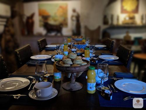 a wooden table with a table set with food and glasses at Algranate - Maison du Tisserand in Flavigny-sur-Ozerain